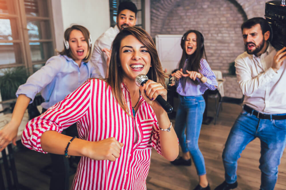 Business People Making Team Training Exercise During Team Building Seminar Singing Karaoke