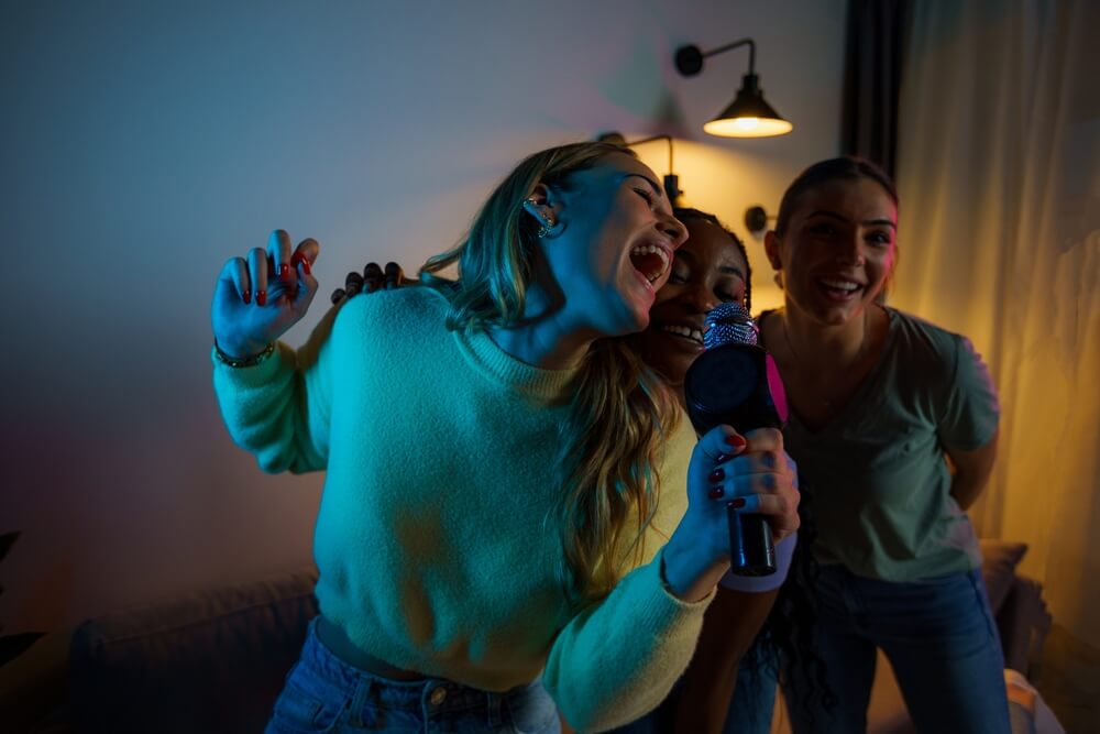 Group Of Happy Friends Singing Karaoke During A Girls Night Party At The Apartment, Singing And Dancing.