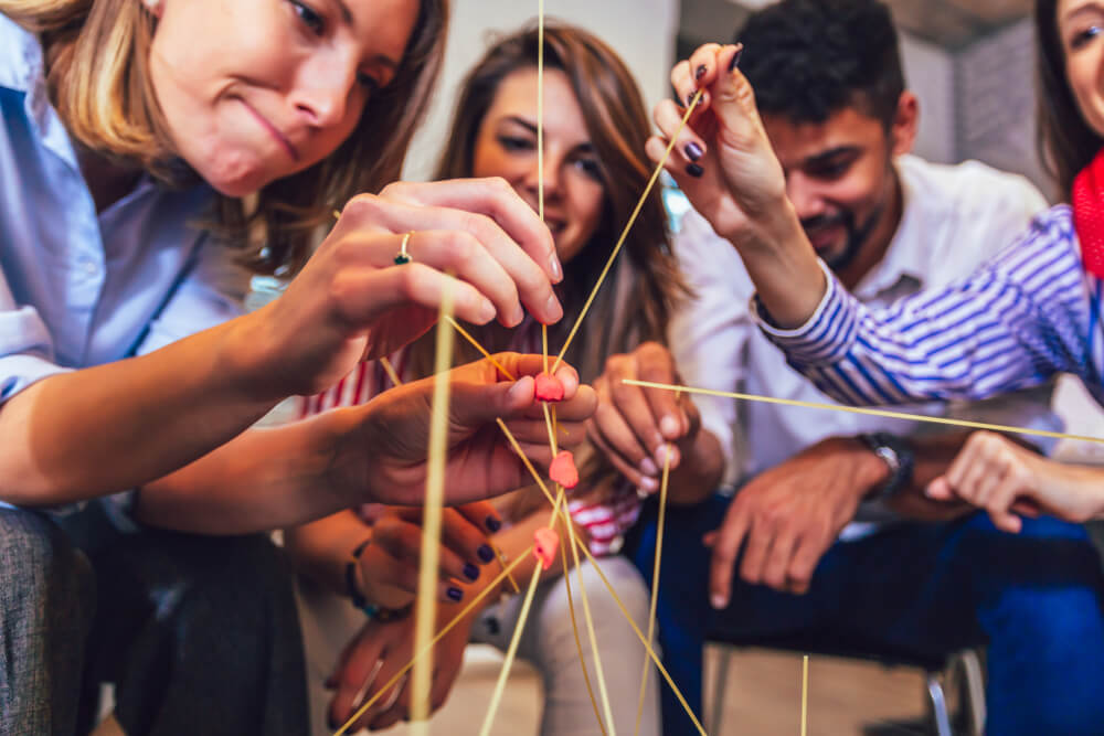 Happy Friendly Business Team Having Fun At Corporate Training, Funny Teambuilding Activity, Playing Spaghetti Game.