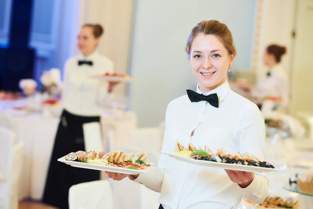 Waitress Occupation. Young Woman With Food On Dishes Servicing In Restaurant During Catering The Event