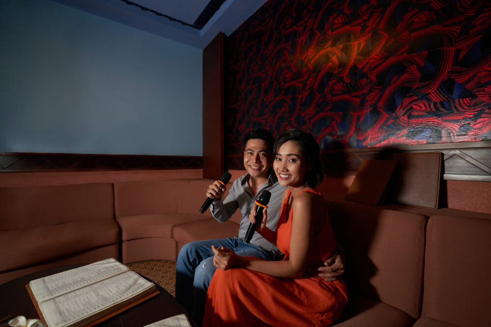 Young couple singing song in karaoke.