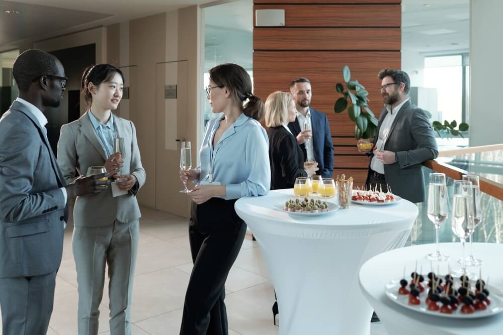 Young intercultural entrepreneurs standing by served tables.