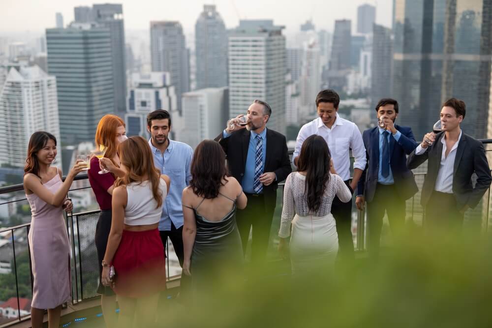 Photo of a group of people on a rooftop bar celebrating the company's success.