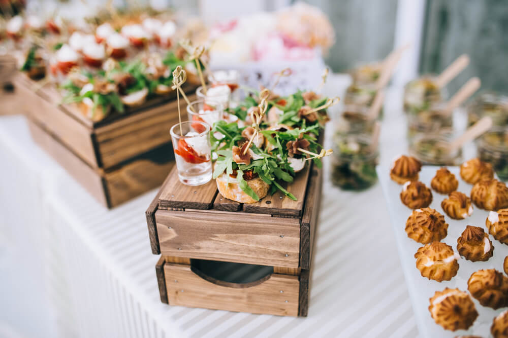 Beautifully decorated catering banquet table with different food snacks and appetizers.