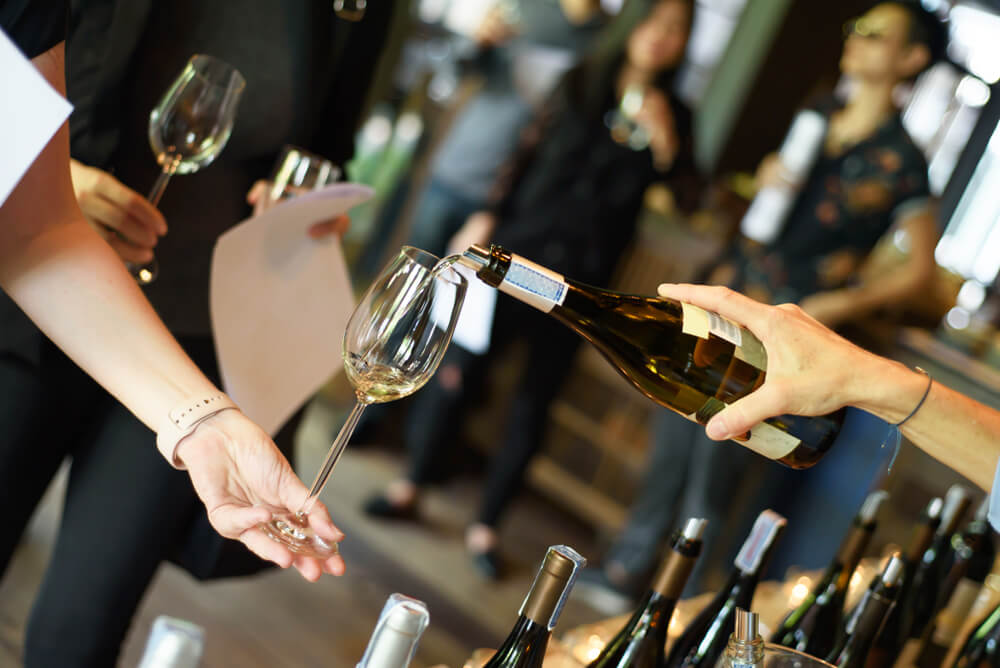 A waitress pouring a glass of wine to celebrate the team's success.
